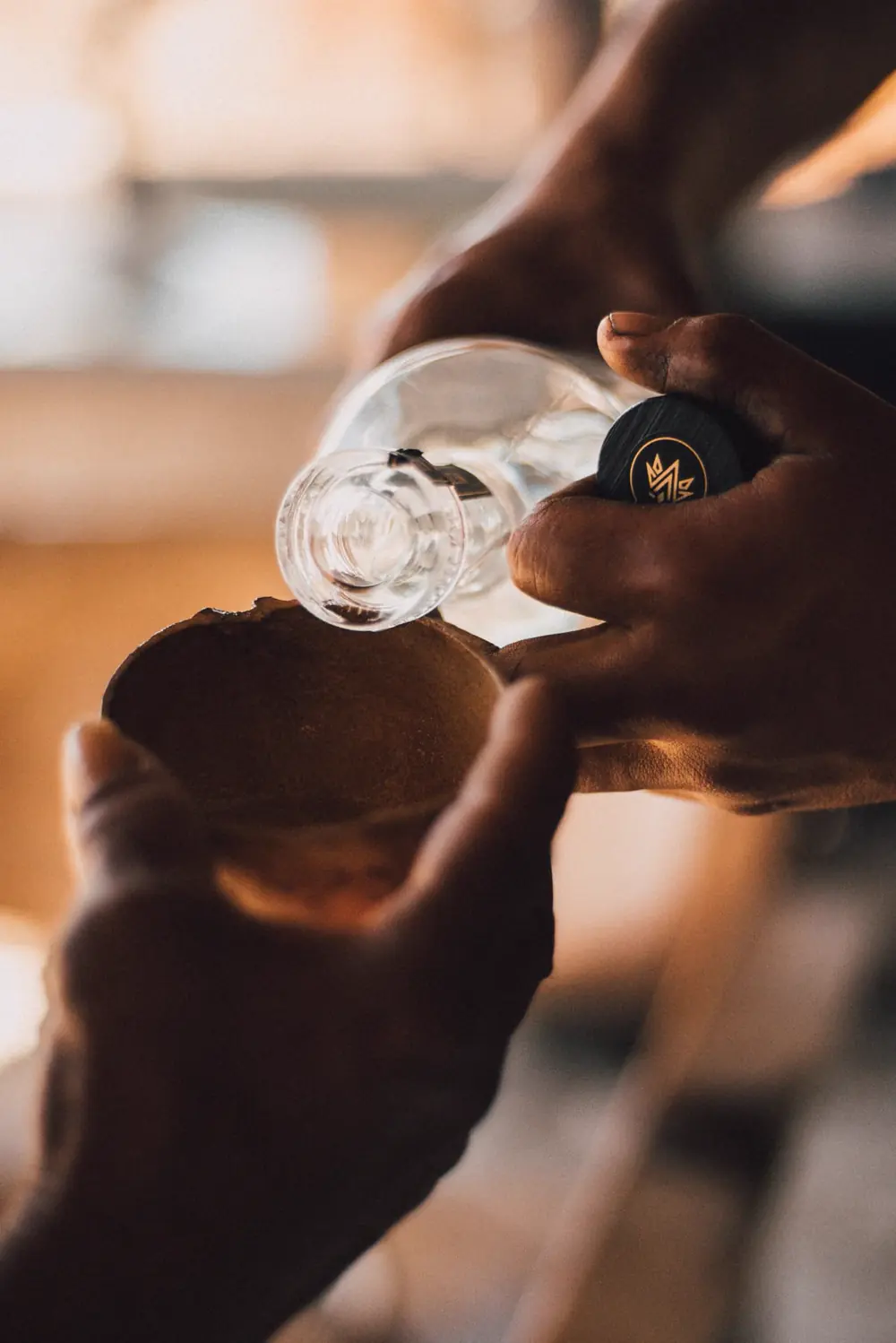 Mezcal saliendo del alambique hacia un vaso de vidrio