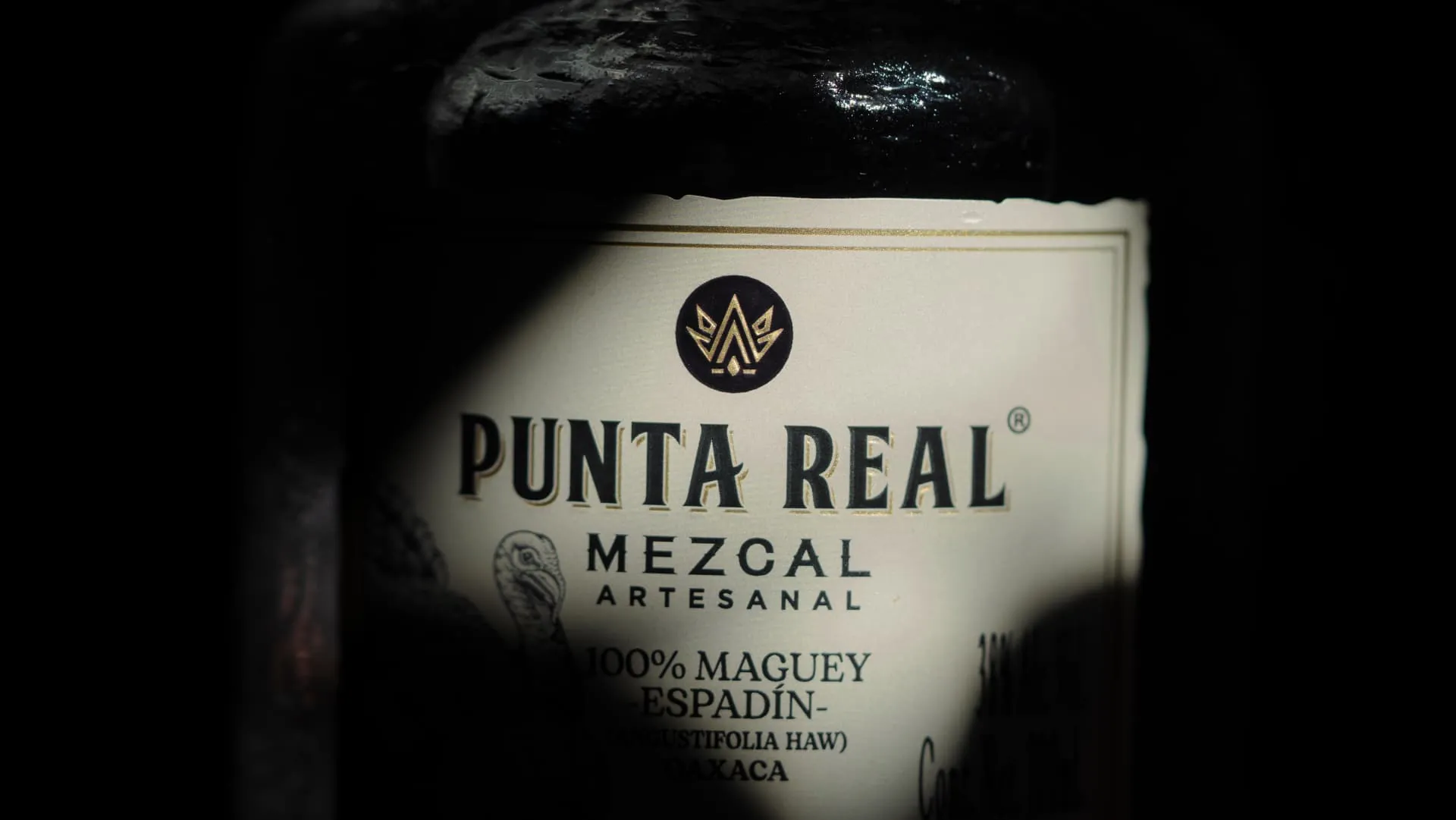 Detalle de la etiqueta de una botella de Punta Real Mezcal Artesanal